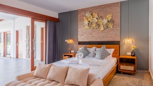 Een moderne slaapkamer met een groot bed, een houten hoofdeinde en decoratieve wandkunst.