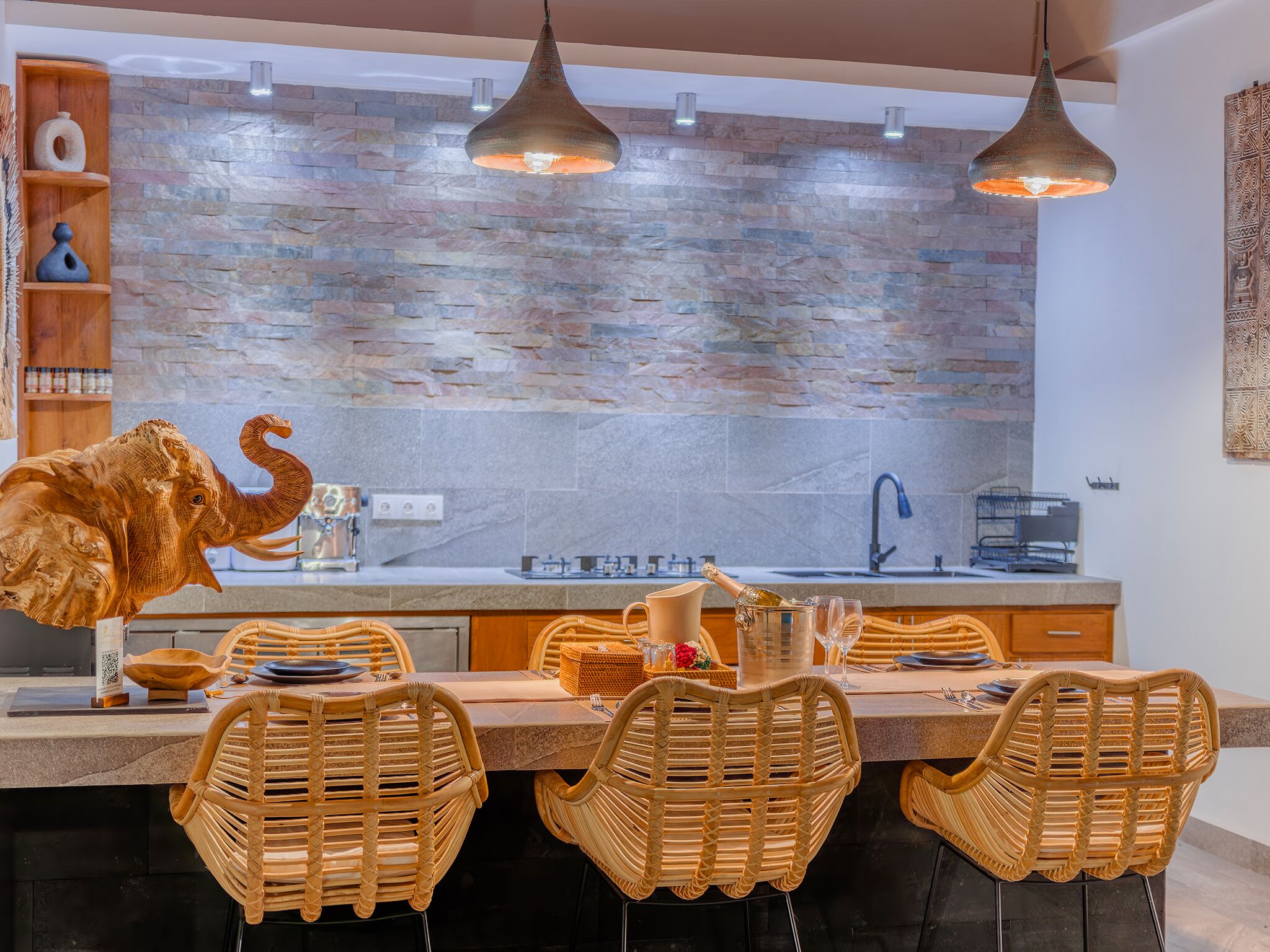 A modern kitchen with a stone backsplash, wooden shelves, and wicker chairs.