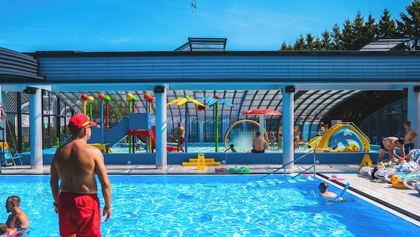 A swimming pool with a covered area, slides, and play structures. - Collins Holiday (Sianożęty)