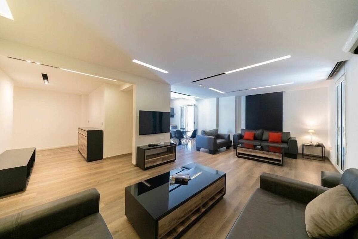 Un salon moderne avec un téléviseur à écran plat, une table basse et un canapé.