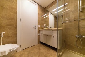 Ein modernes Badezimmer mit Toilette, Waschbecken und Duschbereich.
