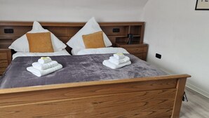 A double bed with a wooden headboard, two nightstands, and a bedside table.
