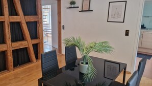 A dining area with a wooden trestle, a black table, and a potted plant.