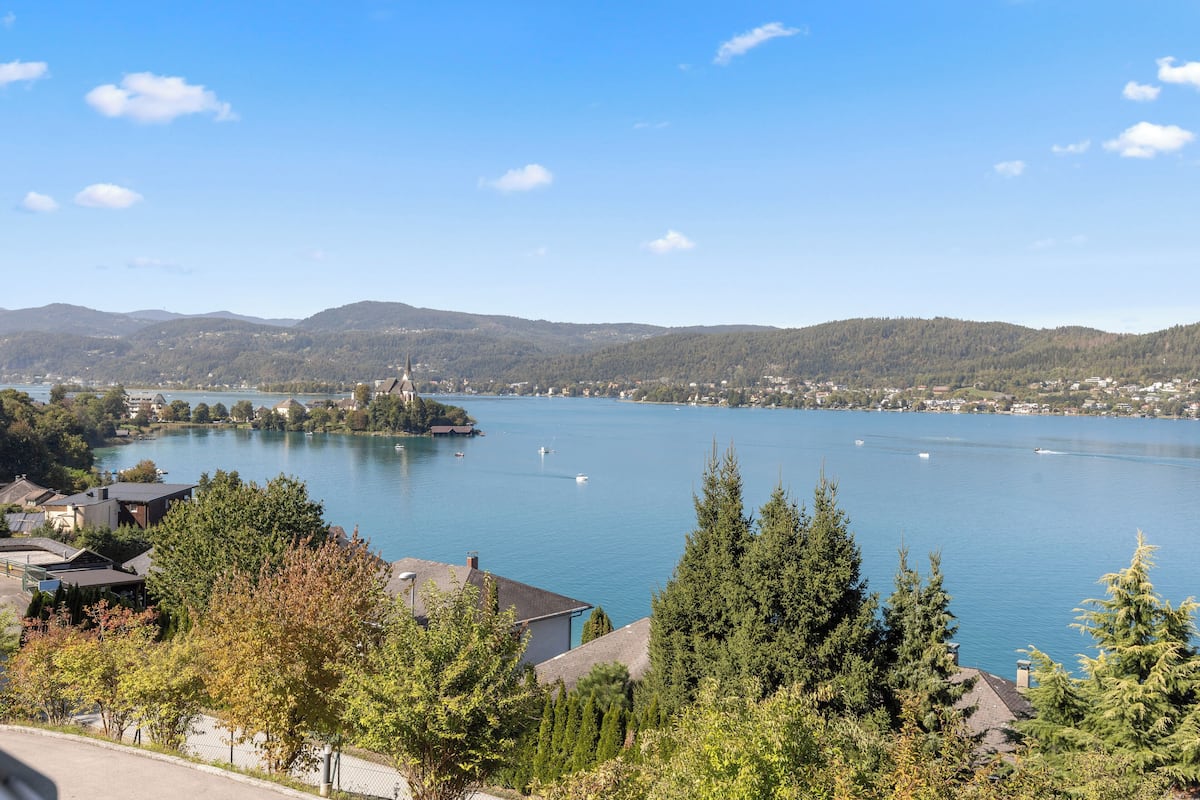 A lakeside view with a church and residential buildings.