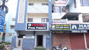 A hotel named "Prem Palace" with a signboard, a medical store, and a shop named "Murga on Wheels".