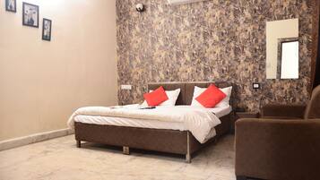 A bedroom with a bed, a brown armchair, a marble floor, and a textured wall.