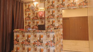 A room with a wall covered in travel-themed wallpaper, a wooden door, and a ceiling fan.