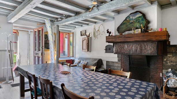 Un comedor con una mesa grande, sillas, una chimenea y vistas al exterior.