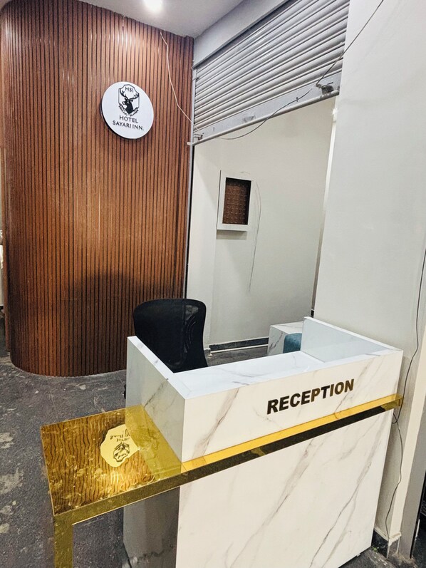 Un mostrador de recepción con encimera de mármol y un cartel que dice 'RECEPTION'.
