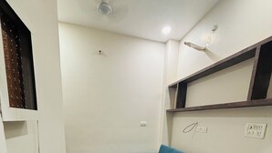Una sala de estar moderna con un sofá azul, una mesa de centro de mármol blanco y un ventilador de techo.