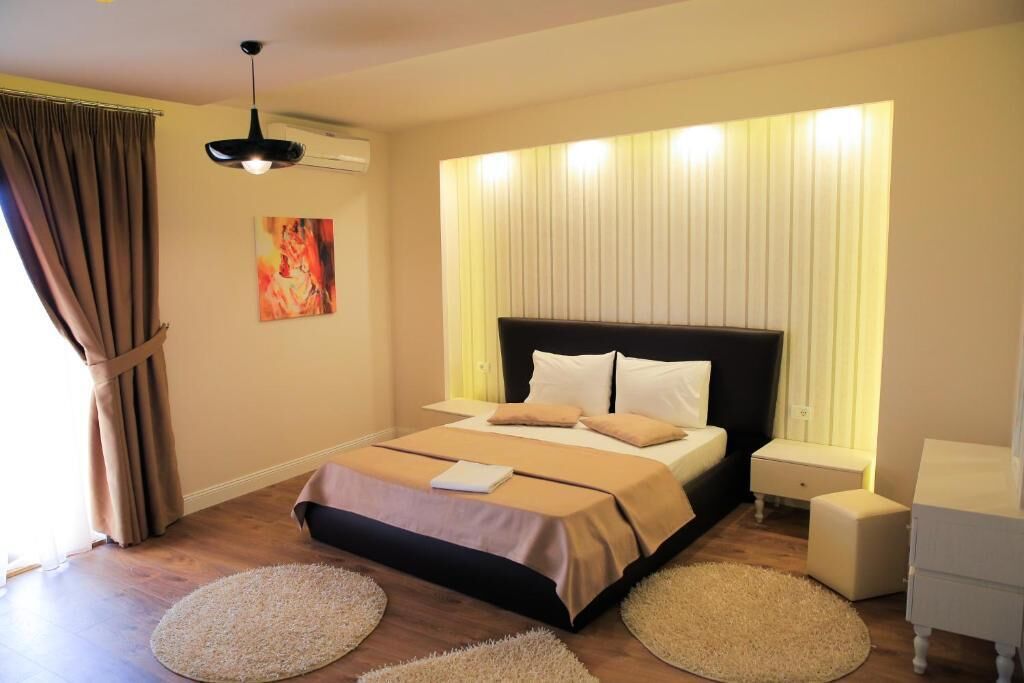 Una camera da letto moderna con un letto grande, comodini e un ventilatore a soffitto.
