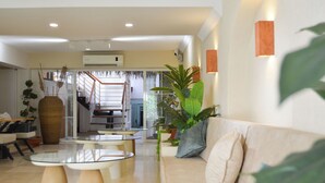 A modern living room with a sofa, glass coffee table, and a staircase leading to an upper level. - niXie Bodrum (Bodrum)