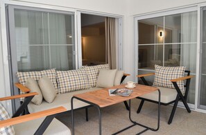 A cozy balcony with a sofa and chairs, a wooden table, and a magazine. - niXie Bodrum (Bodrum)