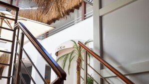 A modern interior with a staircase, a palm tree, and a sign reading "Mie." - niXie Bodrum (Bodrum)