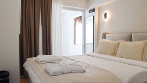 A hotel room with a large bed, a bedside table, a wall-mounted light, and a view of the outdoors. - niXie Bodrum (Bodrum)