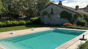 A rectangular swimming pool with a clear blue water surface, surrounded by a tiled deck. - Haven of peace: 8-person gîte with swimming pool in Boisse (Boisse)