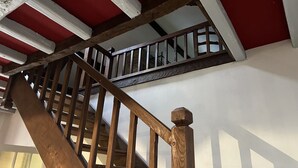 A wooden staircase with a white railing and a red ceiling. - Haven of peace: 8-person gîte with swimming pool in Boisse (Boisse)