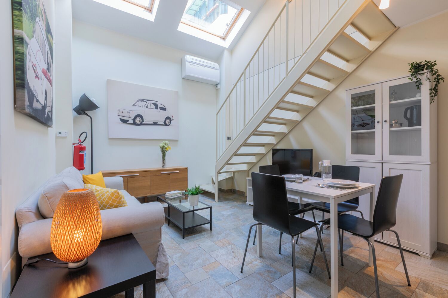 A modern living space with a loft-style ceiling, a dining area, and a kitchen.