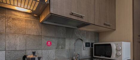 A modern kitchen with a built-in coffee maker, a microwave, and a sink.