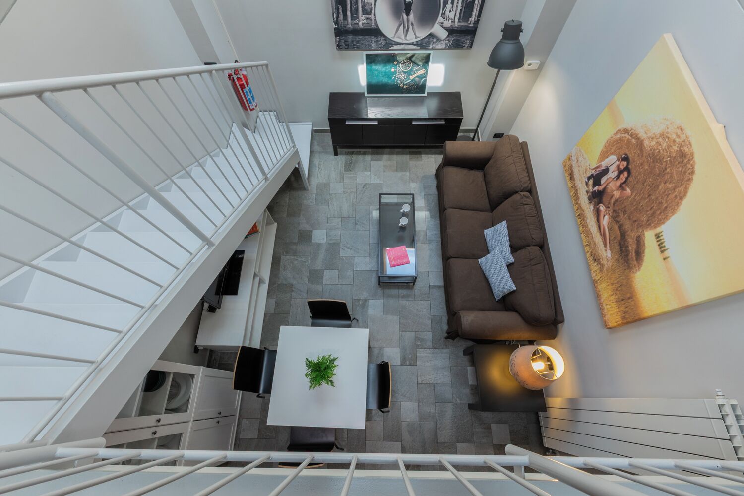 A modern living room with a sofa, coffee table, and a painting on the wall.