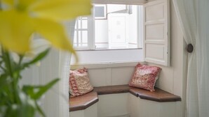 A bay window with two cushioned seats and a view of the outside.