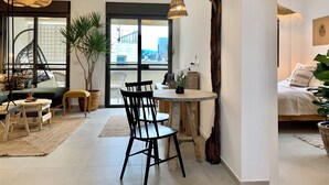 Ein modernes Wohnzimmer mit Essbereich, großen Fenstern und Blick auf die Stadt.