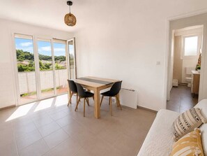 Eine moderne Wohnung mit Essbereich, einem Balkon mit Blick und einem Wohnzimmer.