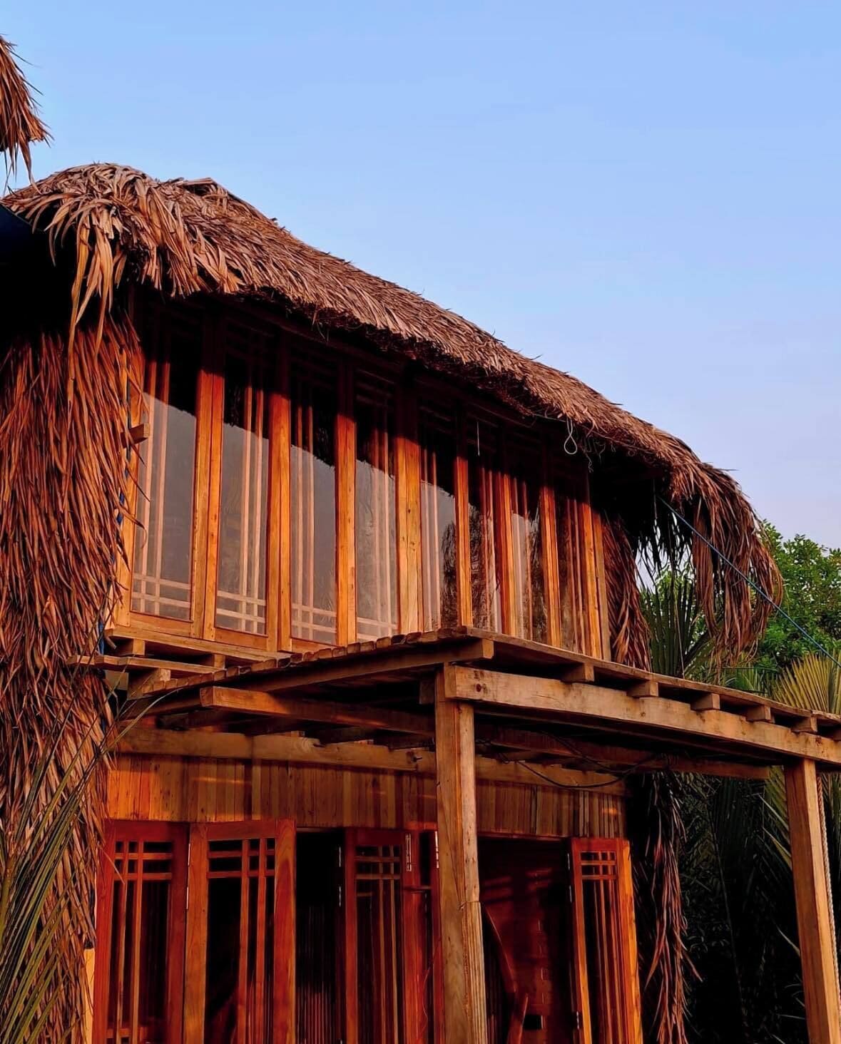 A wooden structure with a thatched roof and multiple windows.