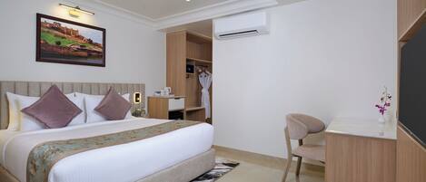 Una habitación de hotel moderna con una cama grande, un escritorio y un armario.