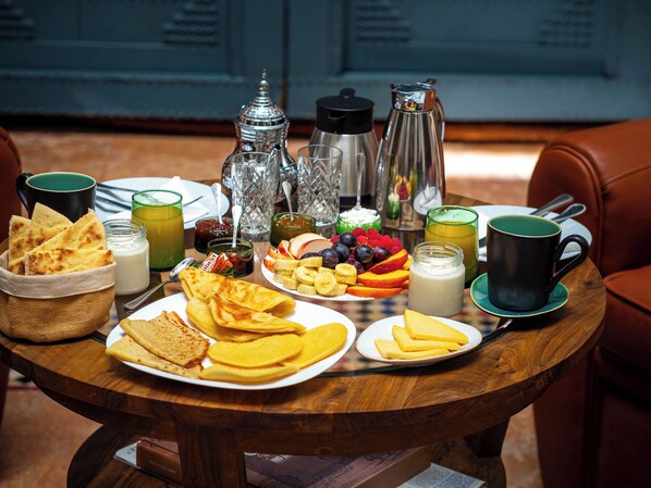 Una mesa de desayuno con diversas comidas, bebidas y salsas.