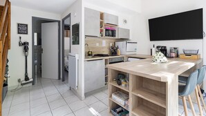 Eine moderne Küche mit Mikrowelle, Kühlschrank und Holzarbeitsplatte.