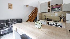 Eine moderne Küche mit Holzausstattung, einem Einbauofen und einer Mikrowelle.