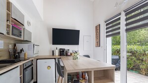 Eine moderne Küche mit Flachbildfernseher, Einbaugeräten und einem Holztisch.