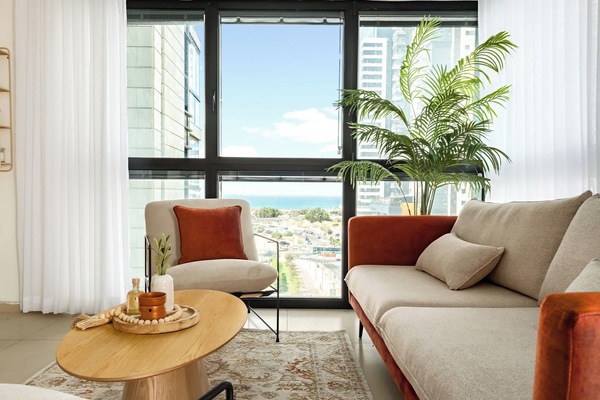 Cozy seating by the window invites coffee, reading, and quiet moments with a leafy backdrop.