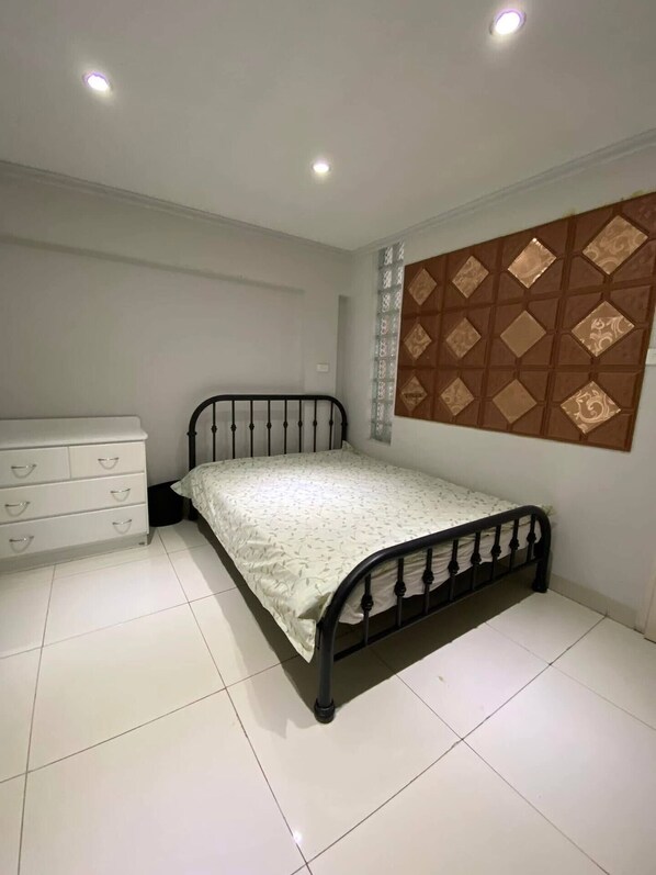 A bedroom with a bed, a dresser, and a decorative wall panel.