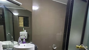 A bathroom with a white sink, a mirror, a towel, and a toilet. - Lautoka accommodation (Lautoka)
