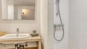 A bathroom with a white sink, a mirror, and a shower with a handheld showerhead. - Colivi Studio Tehuana Cosy Gare Annemasse (Annemasse)