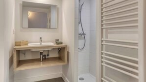 A modern bathroom with a wooden vanity, a mirror, a shower with a white towel rack, and a tiled floor. - Colivi Studio Tehuana Cosy Gare Annemasse (Annemasse)