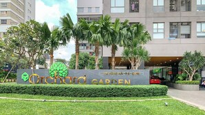 A sign for Orchard Garden with a modern building in the background. - Nice Apartments near Tan Son Nhat Airpot (Ho Chi Minh City)