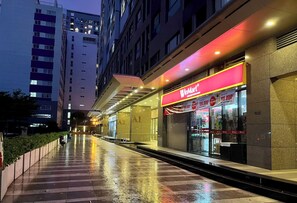 A WinMart store with a bright red sign, located in a high-rise building with reflective floors.