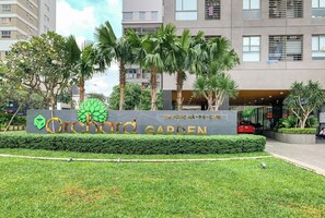 A sign for Orchard Garden with a modern building in the background. - Nice Apartments near Tan Son Nhat Airpot (Ho Chi Minh City)