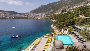 A coastal hotel with a pool, sun loungers, and a view of the sea and mountains. - Kalkan Ayapa Hotel (Kaş)