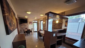 Une cuisine moderne avec un mur en briques, des meubles en bois et un coin repas comprenant des chaises et une table.