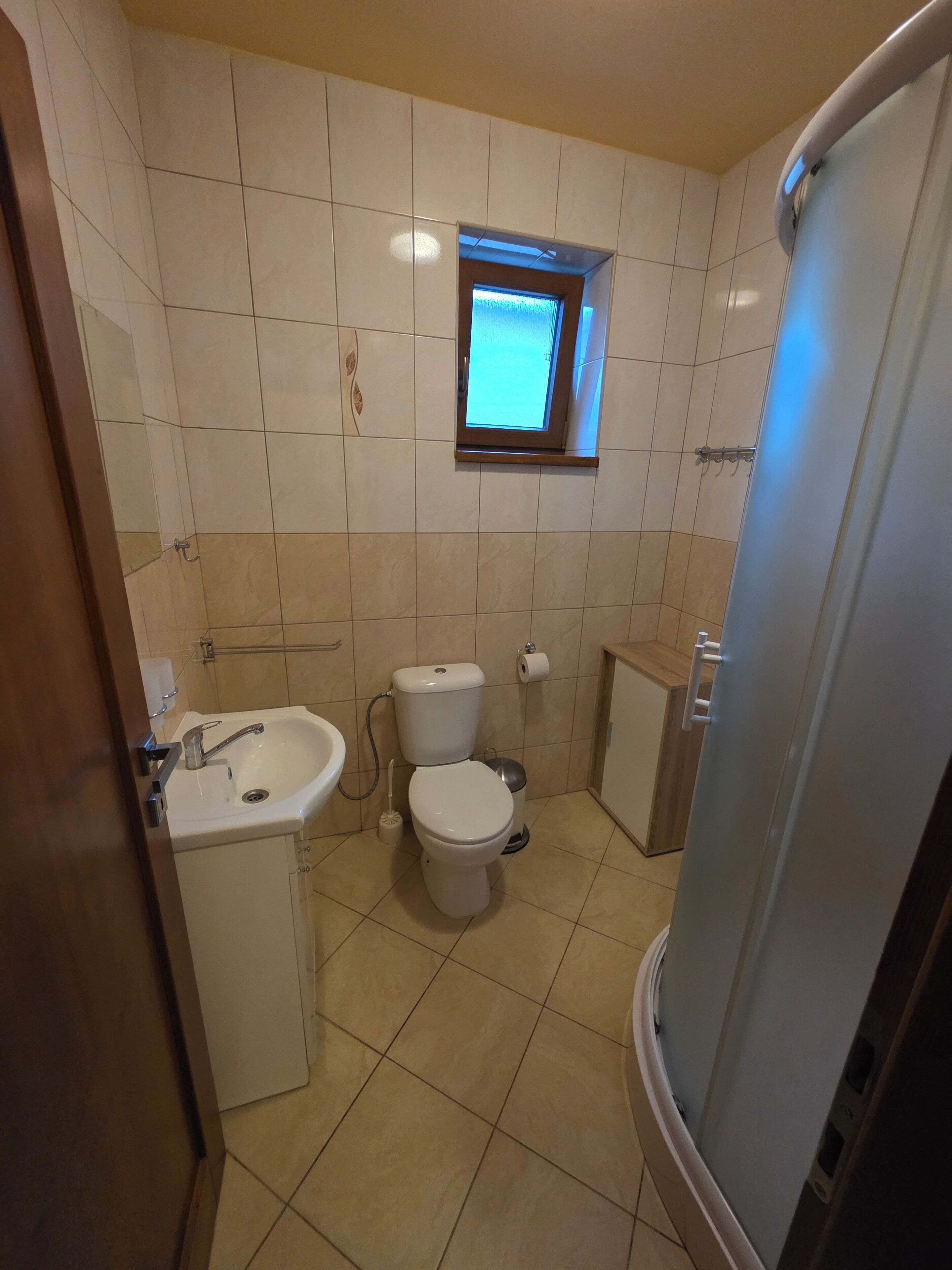 Un bagno con il water, un lavandino e una finestra.