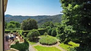 A view of a garden with a table and chairs, surrounded by neatly trimmed hedges and trees. - Villa Spada - countryside - Pool - 30 min from the Sea (Toscana)