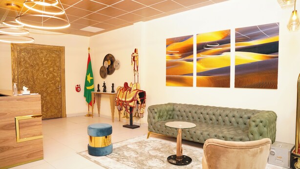 A modern hotel lobby with a green sofa, a round coffee table, and a reception desk. - AB BUSINESS HOTEL  (Nouakchott)