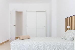 Une chambre à coucher avec un lit, une porte et un panneau fixé au mur.