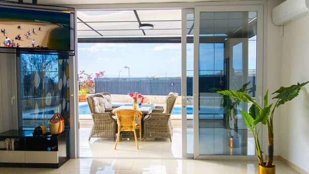 Un salon moderne avec une porte vitrée donnant sur un patio extérieur.