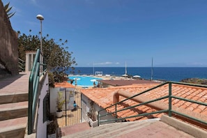 A pool area with a view of the sea, a staircase leading to a terrace, and a reception sign. - Sun-Kissed Vacation Home: 3BR Retreat by the Ocean (Callao Salvaje)