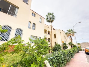 A residential building with multiple balconies, a palm tree, and a parked car. - Sun-Kissed Vacation Home: 3BR Retreat by the Ocean (Callao Salvaje)